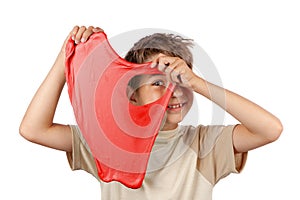 Cheerful boy holding a red slime and looking throw its hole