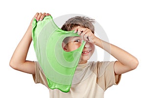 Cheerful boy holding a slime and looking throw its hole. Studio