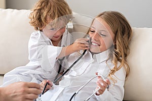 Cheerful boy putting stethoscope on cheek