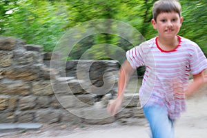 Cheerful boy running in the park