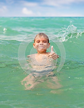 Cheerful boy swimming in the sea