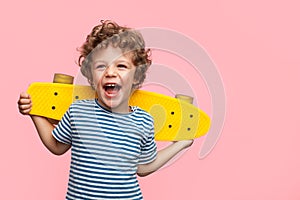 Cheerful boy with yellow longboard