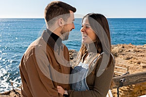 Cheerful boyfriend and girlfriend on terrace near sea