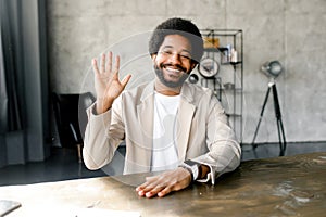 A cheerful Brazilian businessman in a smart casual beige suit in loft office