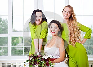 Cheerful bride with bridesmaid holding bouquet