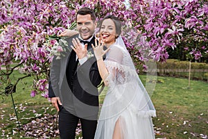 Cheerful bride sticking out tongue near