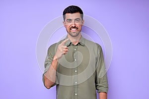 cheerful brunette bearded man demonstrating the letter Z z