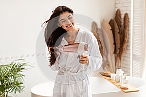 Cheerful Brunette Lady Drying Hair With Blowdryer In Bathroom