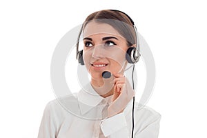 Cheerful brunette woman working in call center with headphones and microphone and smiling aside isolated on white