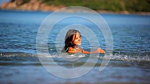 Cheerful brunette young woman in the sea water