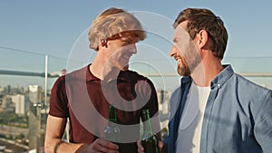 Cheerful buddies enjoy party on rooftop close up. Smiling men talking at hangout