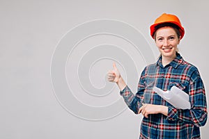 The cheerful builder looks ahead showing a good mood. Thumbs up cool, successful completion of new building