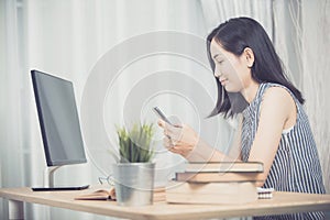 Cheerful business lady working on laptop comouter at home .