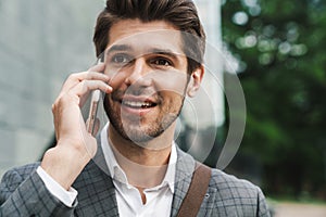 Cheerful business man outdoors talking by mobile phone