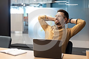 Cheerful Business Man Relaxing Sitting Near Laptop In Modern Office