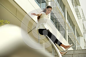 Cheerful Business Woman Going Downstairs Sliding On Rail For Joy