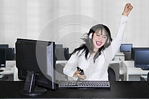 Cheerful business woman hears music in office