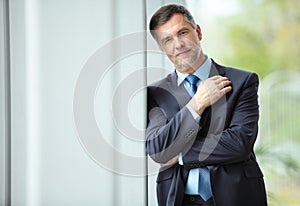 Cheerful businessman with arms folded looking at the camera.