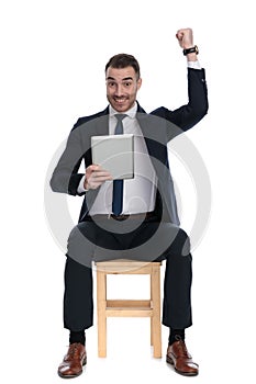 Cheerful businessman celebrating with a tablet in his hand