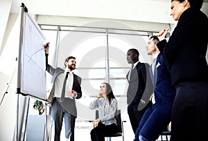 Cheerful businessman discussing new business project with the members of his team