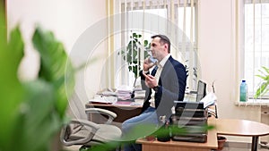 cheerful businessman having phone call at workplace. Portrait of happy business man calling phone indoor.