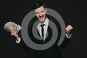 Cheerful businessman holding dollar banknoted in hands isolated