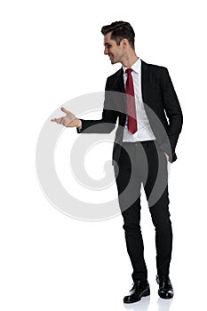 Cheerful businessman holding his hand in his pocket and explaining