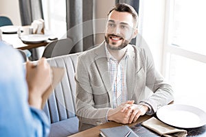 Cheerful businessman making order in restaurant