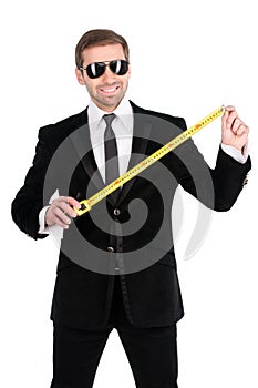 Cheerful businessman measuring the length of business success wi