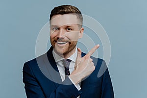 Cheerful businessman pointing with his finger at copy space