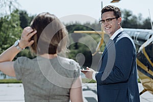 Cheerful businessman talking to colleague at helipad