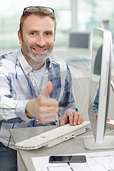 Cheerful businessman thumbs up posing and smiling at camera