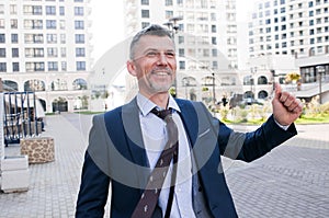 Cheerful businessman thumbs up posing and smiling at camera