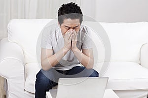 Cheerful businessman using a laptop in sofa