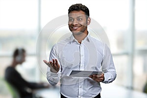 Cheerful businessman wearing white shirt holding digital tablet pc.