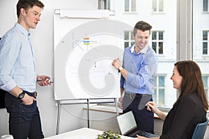 Cheerful Businessmen Looking At Female Colleague In Meeting