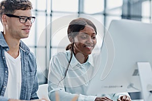 Cheerful businesspeople using a laptop in an office.