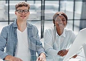 Cheerful businesspeople using a laptop in an office.