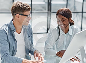 Cheerful businesspeople using a laptop in an office.