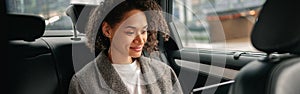 Cheerful businesswoman accountant working on laptop sitting car backseat on the way to office