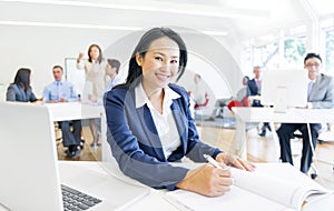 A Cheerful Businesswoman doing her Paperwork