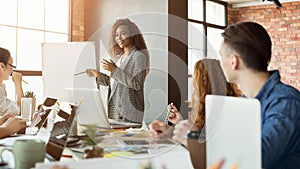 Cheerful businesswoman giving presentation to group