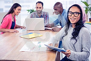 Cheerful businesswoman holding digital tablet