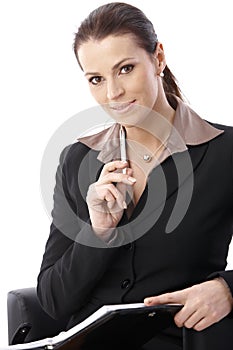 Cheerful businesswoman holding pen