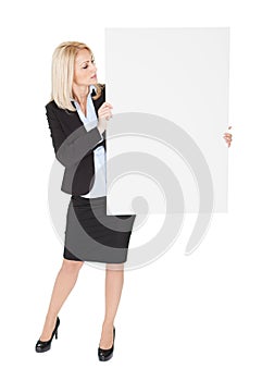 Cheerful businesswomen presenting empty board