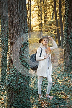 Cheerful carefree autumn woman in park on sunny day. Fall concept. Surprise autumn woman. Autumn girl preparing for