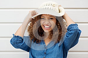 Cheerful carefree woman laughing and wearing summer hat