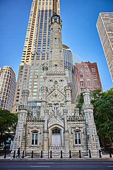 Cheerful castle in city, Chicago original, historic water tower on summer day with blue sky