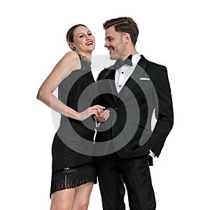 Cheerful casual couple holding hands and laughing