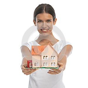 Cheerful casual woman giving home maquette